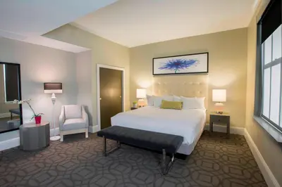 a hotel room with a bed and a chair at Magnolia Hotel Denver, a Tribute Portfolio Hotel in Denver