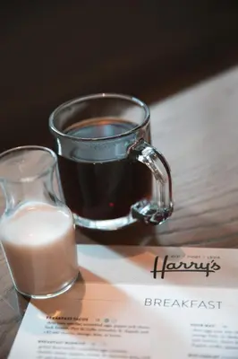 a glass of milk next to a cup of coffee at Magnolia Hotel Denver, a Tribute Portfolio Hotel in Denver