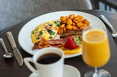 a plate of breakfast food and a glass of orange juice at Hilton Garden Inn Denver/Cherry Creek in Denver