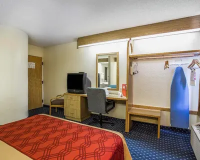 a hotel room with a bed and a desk with a computer at Econo Lodge Denver International Airport in Aurora