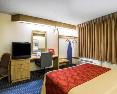 a hotel room with a bed and a desk with a television at Econo Lodge Denver International Airport in Aurora