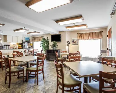 a restaurant with tables and chairs and a kitchen at Econo Lodge Denver International Airport in Aurora