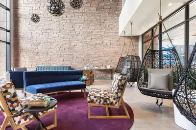 a living room with a couch and chairs and a brick wall at Hilton Garden Inn Boulder in Boulder