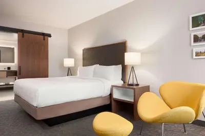 a hotel room with a bed and two chairs at Hilton Garden Inn Boulder in Boulder
