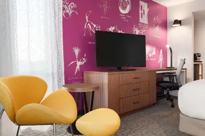 a room with a tv and a desk with chairs at Hilton Garden Inn Boulder in Boulder