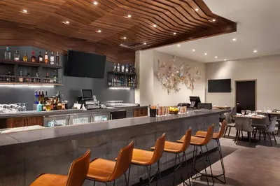 a bar in a restaurant with a counter and chairs at Hilton Garden Inn Boulder in Boulder
