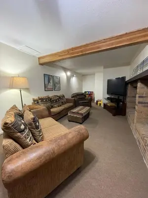 a living room with couches and a flat screen tv at Hideaway Mountain Lodge in Fraser