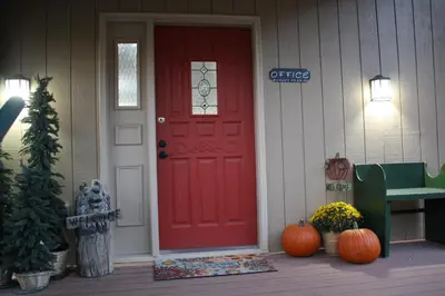 a red door on the front of a house with pumpkins at Hideaway Mountain Lodge in Fraser