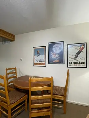 a dining room with a table and four pictures on the wall at Hideaway Mountain Lodge in Fraser