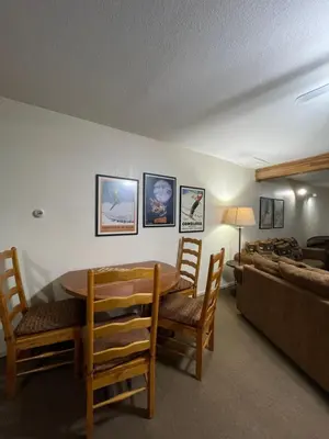 a living room with a table and chairs and a couch at Hideaway Mountain Lodge in Fraser