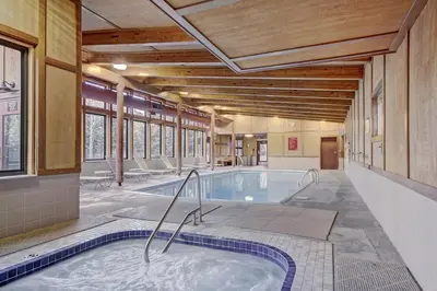 a hot tub in a large room with windows at 2019 Lodgepole Condo in Keystone