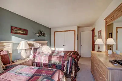 a bedroom with two beds and a desk with two lamps at 2019 Lodgepole Condo in Keystone