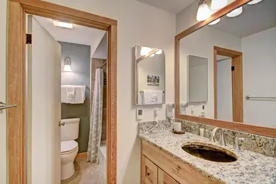 a bathroom with a sink and a toilet and a mirror at 2019 Lodgepole Condo in Keystone