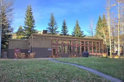 a building with chairs and tables in a yard at 2019 Lodgepole Condo in Keystone