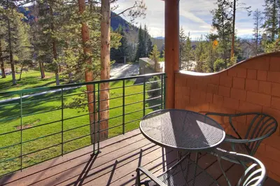 a table and chairs on a balcony with a view at 1926 Soda Springs Ii Townhouse in Keystone