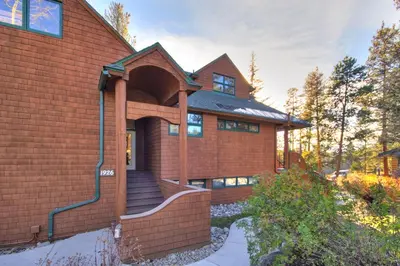 a red brick house with a staircase leading to the door at 1926 Soda Springs Ii Townhouse in Keystone