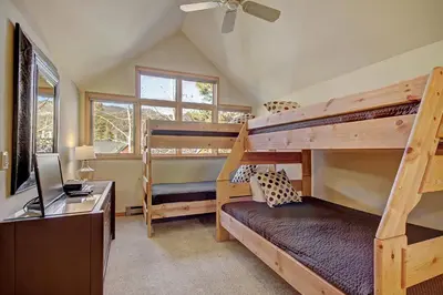 a bedroom with two bunk beds and a desk at 1926 Soda Springs Ii Townhouse in Keystone