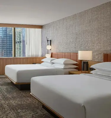 a hotel room with three beds and a large window at Sheraton Denver Downtown Hotel in Denver