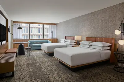 a hotel room with two beds and a couch at Sheraton Denver Downtown Hotel in Denver