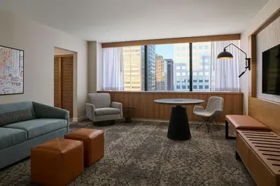 a living room with a couch and a table and chairs at Sheraton Denver Downtown Hotel in Denver