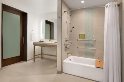 a bathroom with a shower and a tub and a sink at Embassy Suites By Hilton Boulder in Boulder