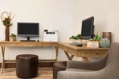 a desk with a computer monitor and a chair at Embassy Suites By Hilton Boulder in Boulder