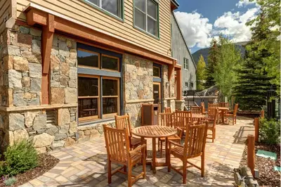 a patio with tables and chairs in front of a building at Black Bear 8078 in Keystone