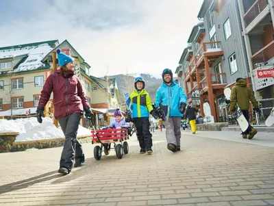 three people walking down a street with a child in a wagon at Black Bear 8078 in Keystone