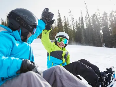 a young child is sitting in the snow at Black Bear 8078 in Keystone