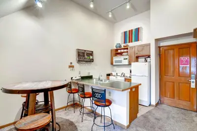 a kitchen with a sink and a counter with stools at Black Bear 8078 in Keystone