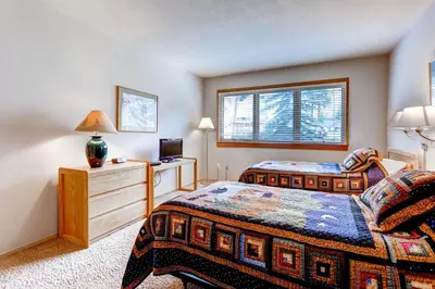 a bedroom with two beds and a tv and a window at Quicksilver 1643 in Keystone