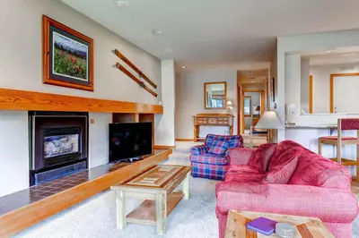 a living room with a red couch and a fireplace at Quicksilver 1643 in Keystone