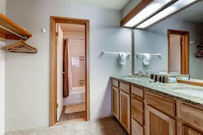 a bathroom with a sink and a mirror and a tub at Quicksilver 1643 in Keystone