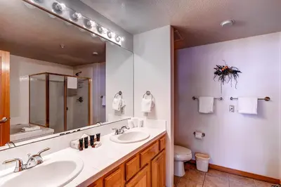 a bathroom with two sinks and a mirror and a toilet at Gateway 5069 in Keystone