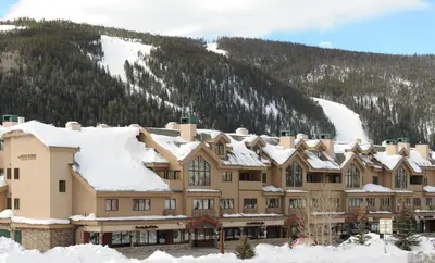 a large building covered in snow in front of a mountain at Gateway 5069 in Keystone