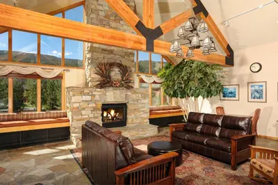 a living room with a stone fireplace and leather furniture at Gateway 5069 in Keystone