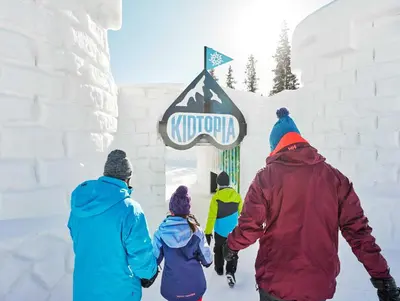 a group of people walking towards a sign in the snow at Gateway 5069 in Keystone