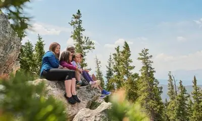 a group of people sitting on top of a rock at Expedition Station 8566 in Keystone