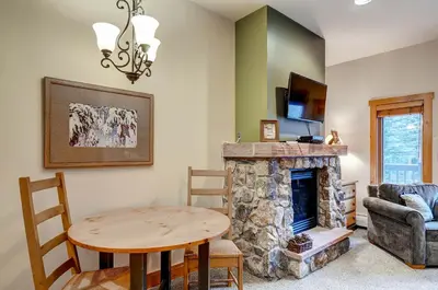 a living room with a table and a fireplace at Expedition Station 8566 in Keystone