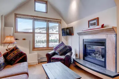 a living room with a fireplace and a couch at Silver Mill 8289 in Keystone