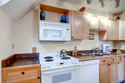 a kitchen with white appliances and wooden cabinets at Silver Mill 8289 in Keystone