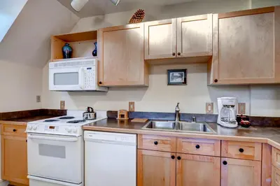 a kitchen with white appliances and wooden cabinets at Silver Mill 8289 in Keystone