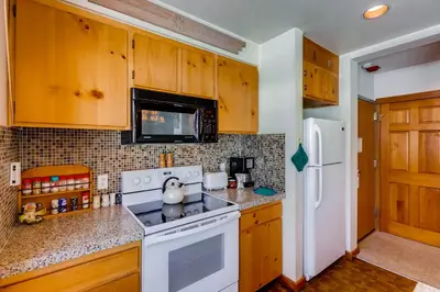 a kitchen with a stove and a white refrigerator at Decatur 1775 in Keystone