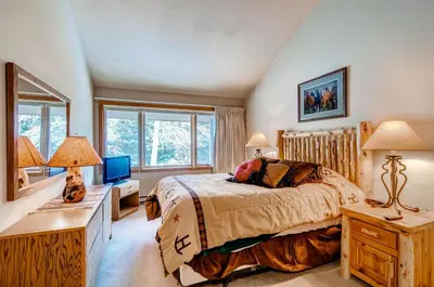 a bedroom with a bed and a desk with two lamps at Lenawee 1735 in Keystone