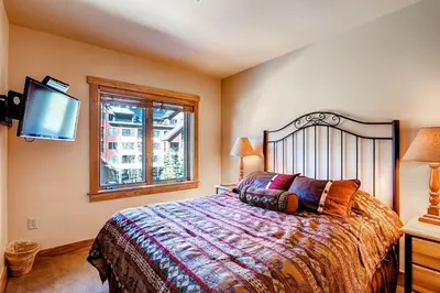 a bedroom with a bed and a flat screen tv at Red Hawk 2272 in Keystone