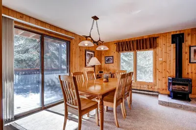 a dining room with a table and chairs and a wood stove at Key Condo 2950 in Keystone