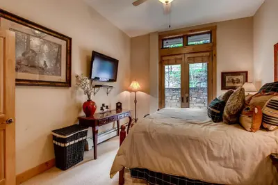 a bedroom with a bed and a tv on the wall at Timbers 3060 in Keystone