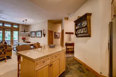 a kitchen with a counter and a living room at Timbers 3060 in Keystone
