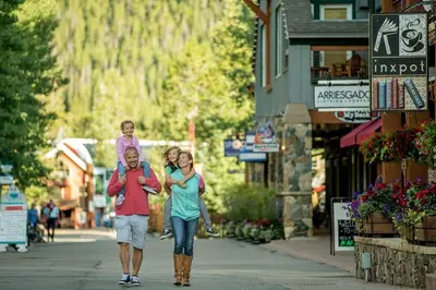 a man and woman walking down a street with a child on their backs at Timbers 3060 in Keystone