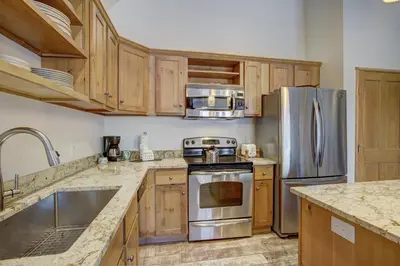 a kitchen with wooden cabinets and stainless steel appliances at Black Bear 8079 in Keystone